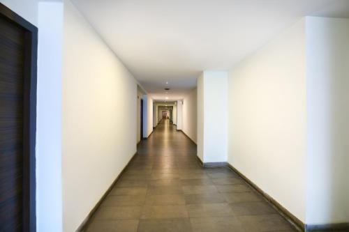 un pasillo vacío en un edificio de oficinas con paredes blancas en Super Collection O Skywalk Hotel, en Chennai
