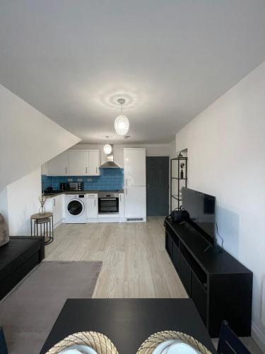 a large living room with a black table and a kitchen at 1 Bedroom Flat in Bedford in Bedford