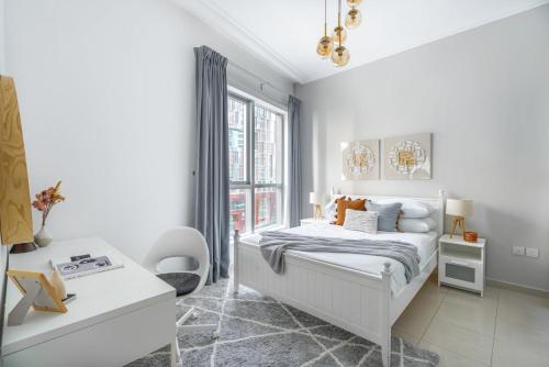 a white bedroom with a bed and a window at GuestReady - Comfort Stay l Close To Marina Mall in Dubai