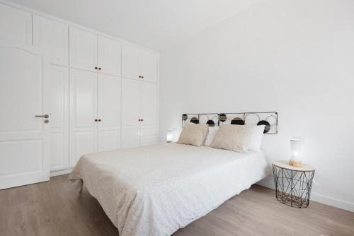 a white bedroom with a large bed with white cabinets at Casa Alsa Beach in Icod de los Vinos