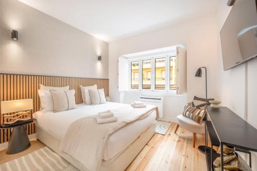 - une chambre blanche avec un grand lit et une fenêtre dans l'établissement GuestReady - CityHomes Lisbon Delight, à Lisbonne