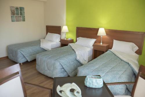 two beds in a room with two tables and two lamps at Park View Hotel & Residences in Campana