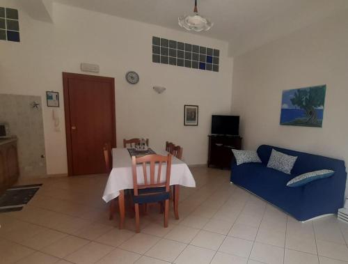 ein Wohnzimmer mit einem Tisch und einem blauen Sofa in der Unterkunft Radici Blu intero alloggio in Siderno Marina
