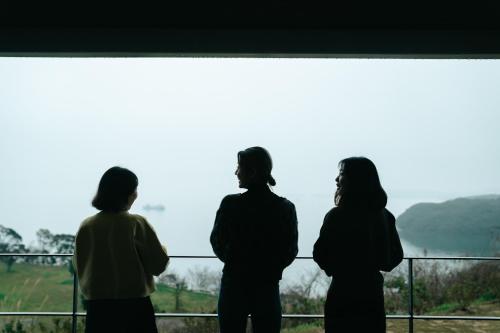 three women standing in front of a window at HARIO Beach Walk in Sakihario