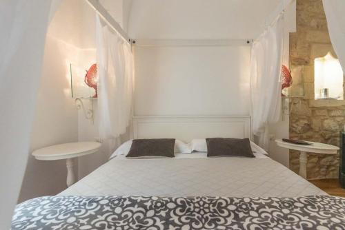 a white bedroom with a bed and a table at Le Nicchie luxury rooms in Lecce