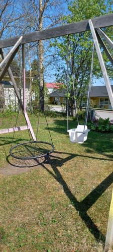 an empty swing in a yard with a house at Vita villan in Haparanda