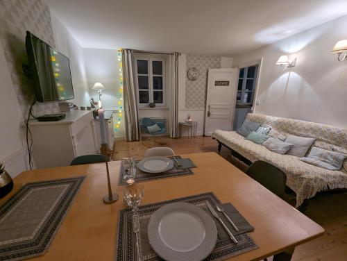 un salon avec une table et un canapé dans l'établissement Appartement lumineux et calme proche mer a pieds, à Saint-Malo