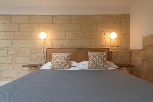 1 dormitorio con 1 cama grande y 2 almohadas en Le Nicchie luxury rooms, en Lecce