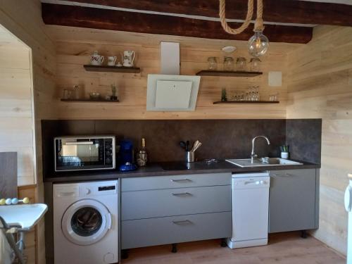 une cuisine avec un évier et une machine à laver dans l'établissement Petite maison avec piscine, à Vezels-Roussy