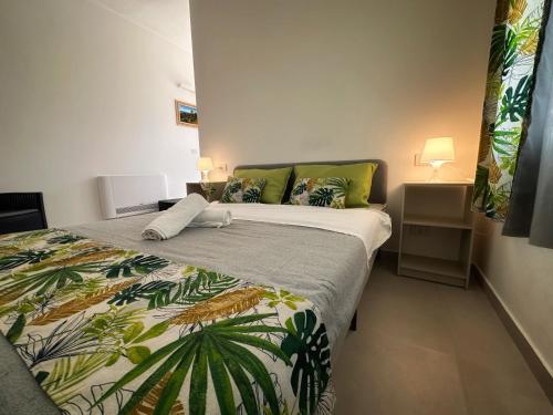 a bedroom with a bed with a tropical bedspread at Villa Isma Superior Rooms in Realmonte