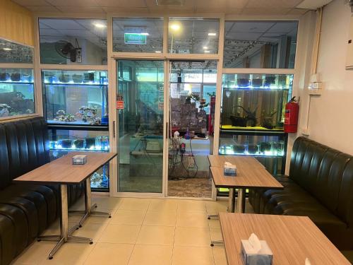 a restaurant with two tables and chairs and a window at Alongkorn hotel by SB in Samut Songkhram