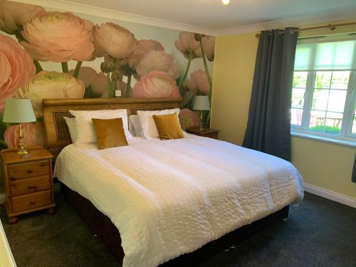ein Schlafzimmer mit einem Bett mit einem Blumenbild an der Wand in der Unterkunft The Albany Apartments in St Peter Port