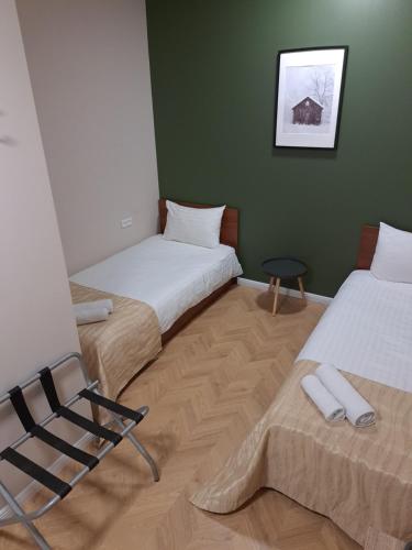two beds sitting next to each other in a room at Pušelė in Šiauliai