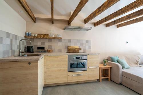a kitchen with a stove and a couch in a room at Bed en Wijn - Suite Landhuisje in Staphorst