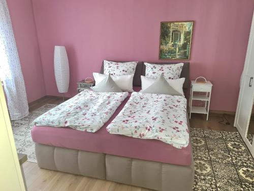a bedroom with a large bed with pink walls at Ferienwohnung Kespergarten in Witzenhausen