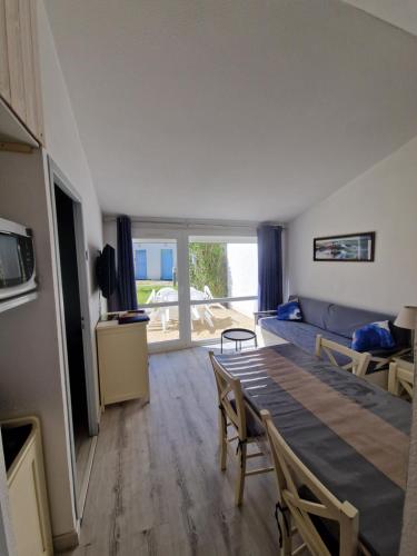 - un salon avec une table à manger et un canapé dans l'établissement Charmante petite maison pour 4 personnes CDC FR90C10G, à Dolus-d'Oléron