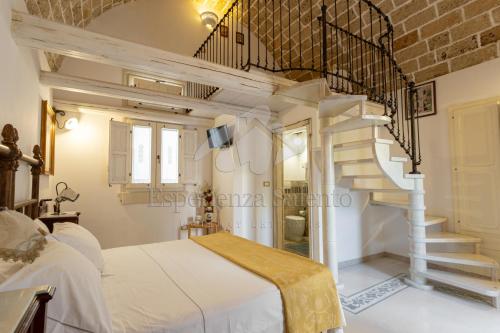 a bedroom with a white bed and a spiral staircase at SANTA LUCIA DIMORA in Taviano