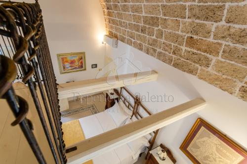a staircase with a brick wall and wooden shelves at SANTA LUCIA DIMORA in Taviano
