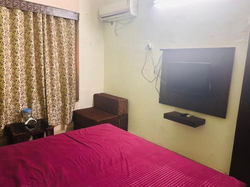 1 dormitorio con 1 cama y TV de pantalla plana en Hotel Krishna Palace, en Nueva Delhi