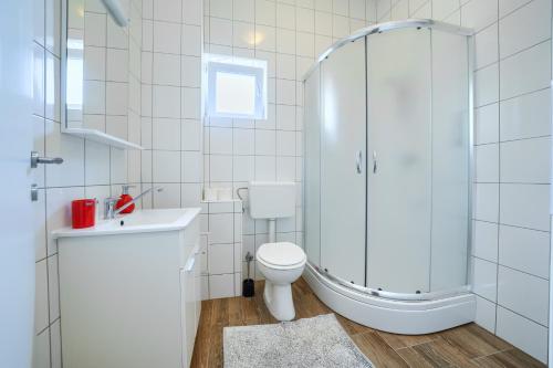 a bathroom with a shower and a toilet and a sink at Cozy New Apartments with Private Pool Podstrana in Podstrana