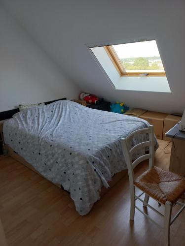 une chambre avec un lit, une chaise et une fenêtre dans l'établissement L'Oasis, au Mans