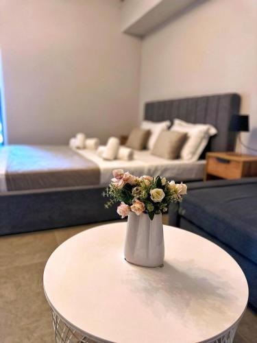un vaso con fiori su un tavolo in soggiorno di Jolie Studios & Apartments a Eforie Nord