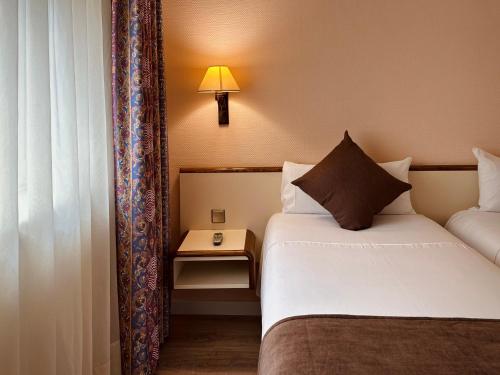 a hotel room with a bed and a table with a lamp at Andorra Palace in Andorra la Vella