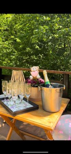 a table with glasses and a bucket and a bottle of wine at Kuca za odmor Marjanovic in Gornji Milanovac