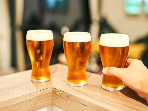 three glasses of beer on a wooden table at Rakuten STAY Nikko Hoden in Nikko
