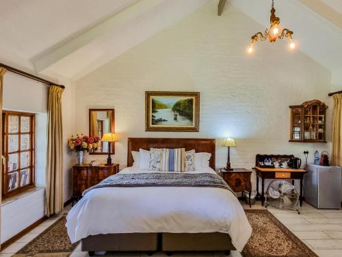 Un dormitorio con una cama grande y una lámpara de araña. en Critchley Hackle Lodge, en Dullstroom