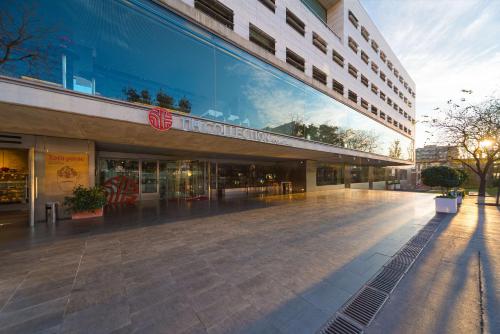 a large building with a walkway in front of it at NH Collection Barcelona Constanza in Barcelona