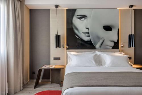Un dormitorio con un gran cartel de dos mujeres en NH Collection Madrid Suecia, en Madrid
