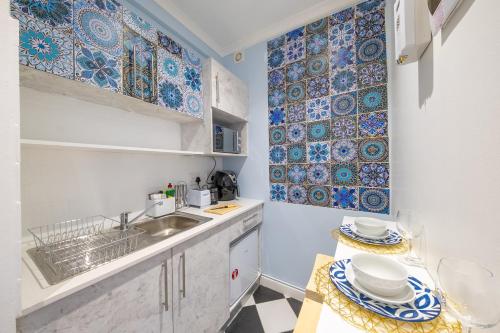 a kitchen with blue and white tiles on the wall at Cosy and Central in Claremont in Cape Town