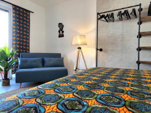 a bedroom with a bed and a blue couch at Mawulo - Stadtwohnung im Zentrum mit Balkon in Neustadt an der Weinstraße