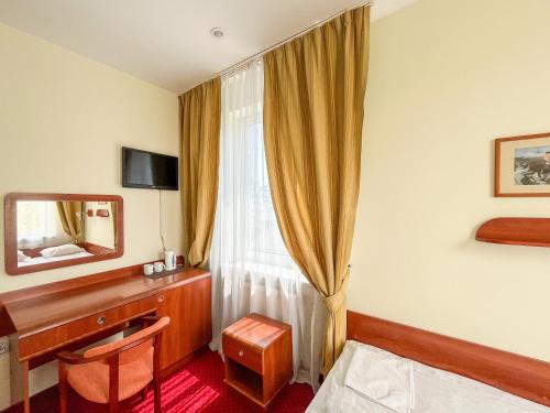 a hotel room with a bed and a desk and a window at Fry House in Warsaw