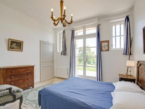 - une chambre avec un lit bleu et un lustre dans l'établissement Holiday Home Les écuries de Callenville by Interhome, à Trouville-sur-Mer