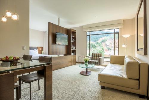 un soggiorno con divano e una sala da pranzo di NH Collection Bogota Hacienda Royal a Bogotá