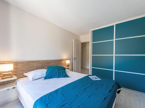 une chambre avec un grand lit et un mur bleu dans l'établissement Apartment Caesar Domus-1 by Interhome, à Saint-Tropez