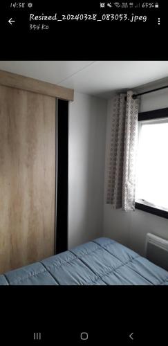 una camera con un letto accanto a una finestra di Vacances contis plage a Saint-Julien-en-Born