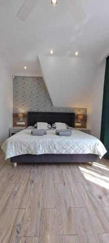 a bedroom with a large bed and a wooden floor at Helios in Ustka