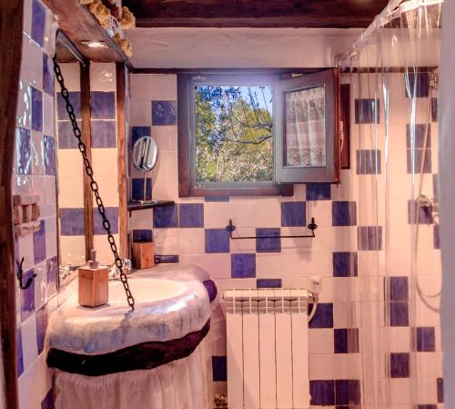 een badkamer met een wastafel en een raam bij Les Olles in Regués
