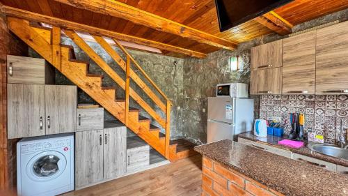 a kitchen with wooden cabinets and a staircase at Cottage Gudauri in Gudauri