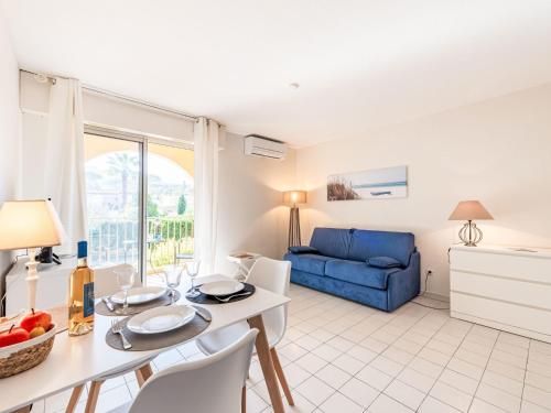 un salon avec une table et un canapé bleu dans l'établissement Studio Caesar Domus-2 by Interhome, à Saint-Tropez