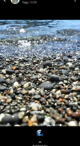a group of rocks on a beach near the water at La Piccola Barca in Camogli
