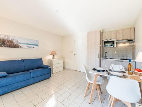 un salon avec un canapé bleu et une table dans l'établissement Studio Caesar Domus-2 by Interhome, à Saint-Tropez