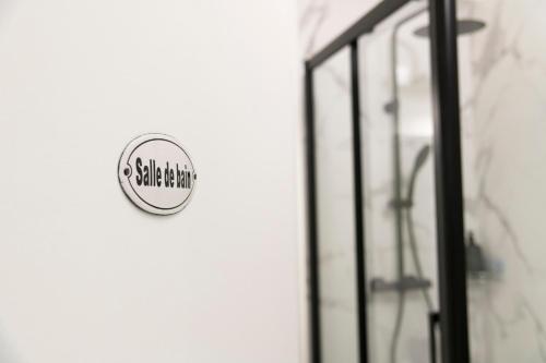 a sign on the side of a bathroom with a shower at Les Cerisiers RdC Lumineux, Jardin, Terrasse in Baisieux