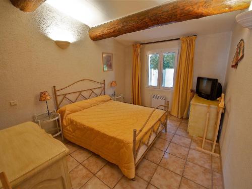 1 dormitorio con 1 cama y TV en Holiday Home Cucuron by Interhome en Cucuron
