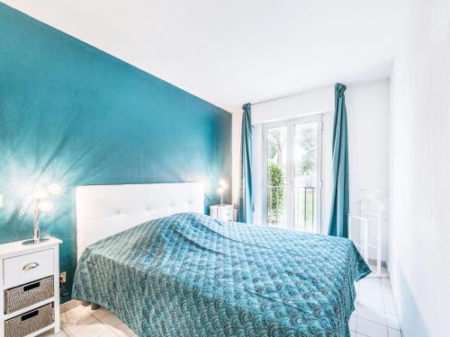 une chambre avec un lit et un mur bleu dans l'établissement Apartment Caesar Domus-4 by Interhome, à Saint-Tropez