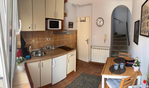 una cucina con lavandino e tavolo in una stanza di Garsonjera Zvezdara a Belgrado