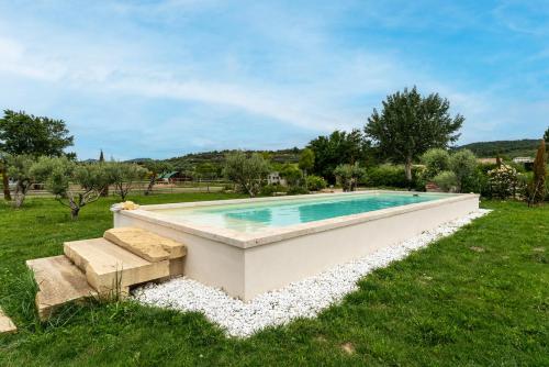 - une piscine avec un banc dans la cour dans l'établissement Le cabanon de Modène, à Modène
